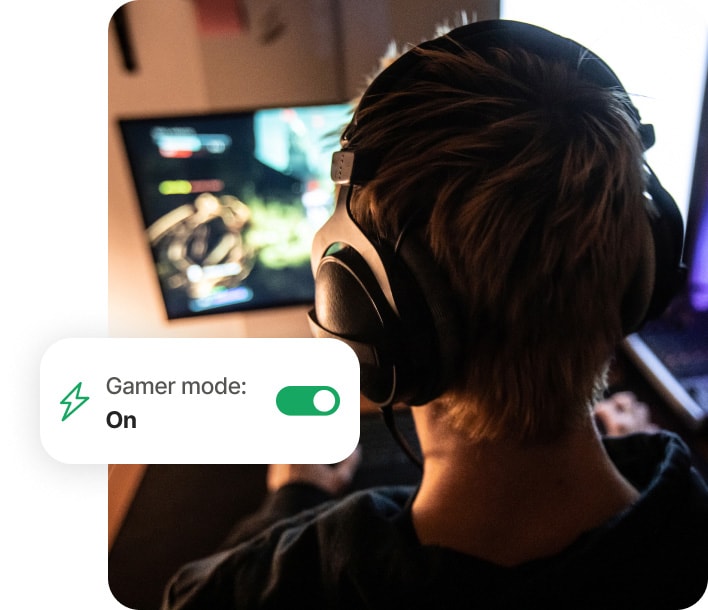 Chłopak grający na komputerze i używający Norton 360 for Gamers.